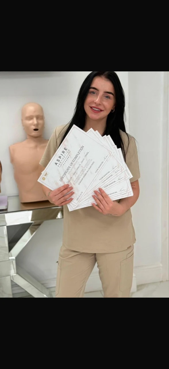Shania holding her aesthetics training certificates
